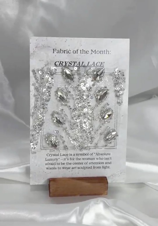 The fabric side of a card on its wooden stand: a Crystal Lace swatch